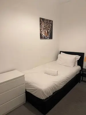a bed in a bedroom with a picture on the wall at The Fabulous Gem in Wallasey in Wallasey