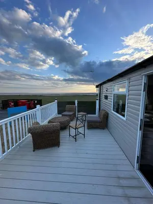 a large deck with chairs and a table on it at Sea view 1 in Heysham