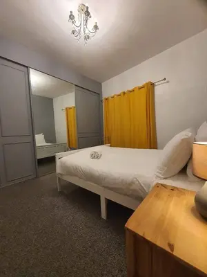 a bedroom with a large bed and a mirror at Warm & Welcoming Balfour Getaway in Wallasey