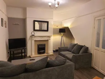 a living room with two couches and a fireplace at Warm & Welcoming Balfour Getaway in Wallasey