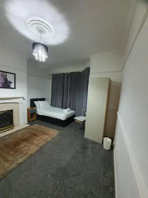 a living room with a bed and a chandelier at Warm & Welcoming Balfour Getaway in Wallasey