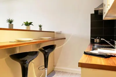 a kitchen with a counter with two stools in it at For Students Only Windsor Court in Liverpool in Liverpool