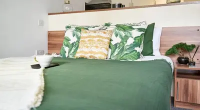 a bed with green sheets and pillows on it at For Students Only Windsor Court in Liverpool in Liverpool