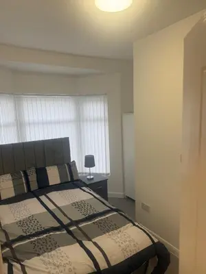 a bedroom with a bed and a lamp in it at Stylish Dream Home with 4 En-Suite Bedrooms in Liverpool