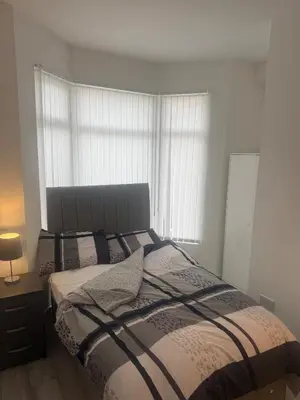 a bedroom with a bed and a window at Stylish Dream Home with 4 En-Suite Bedrooms in Liverpool