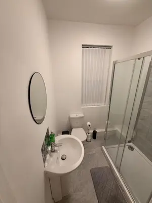 a bathroom with a toilet and a sink and a mirror at Stylish Dream Home with 4 En-Suite Bedrooms in Liverpool