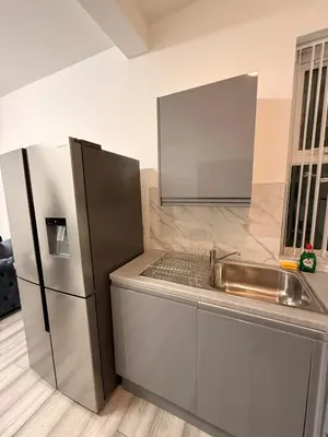 a kitchen with a stainless steel refrigerator and a sink at Stylish Dream Home with 4 En-Suite Bedrooms in Liverpool