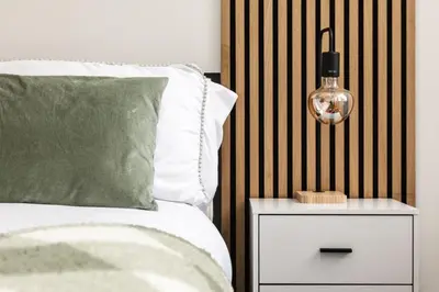 a bed with a side table with a lamp on it at Dreams stay in Preston