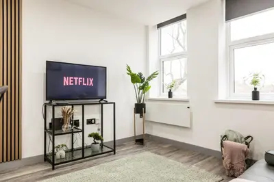 a living room with a television on a tv stand at Dreams stay in Preston