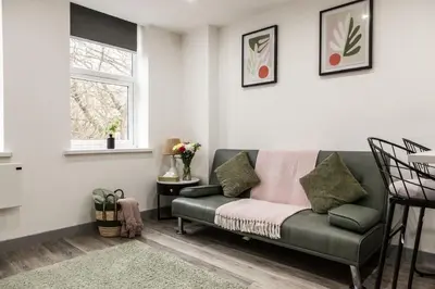 a living room with a couch and a window at Dreams stay in Preston