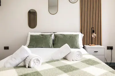 a bedroom with a bed with towels on it at Dreams stay in Preston