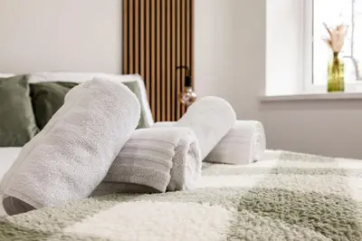 a pile of towels sitting on top of a bed at Dreams stay in Preston