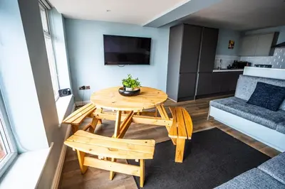 a living room with a table and a couch at Soho Duplex Promenade Seaview Apartment in Blackpool