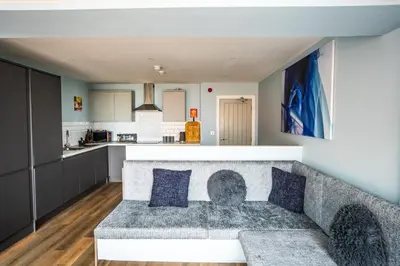 a living room with a couch and a kitchen at Soho Duplex Promenade Seaview Apartment in Blackpool