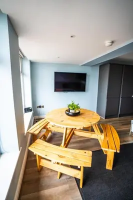 a room with a wooden table and two benches at Soho Duplex Promenade Seaview Apartment in Blackpool