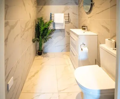 a bathroom with a toilet and a potted plant at Soho Duplex Promenade Seaview Apartment in Blackpool