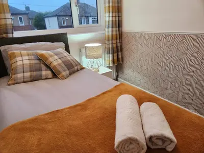 a bed with two towels on it with a window at Kashkana Haven - Blackburn in Cherry Tree