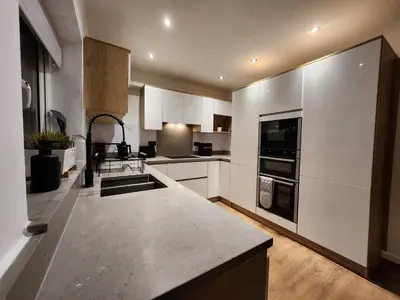 a large kitchen with white cabinets and a counter top at Kashkana Haven - Blackburn in Cherry Tree