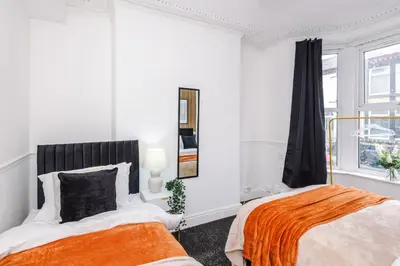 a white bedroom with two beds and a window at Modern 3BR House in Liverpool - Garden in Liverpool
