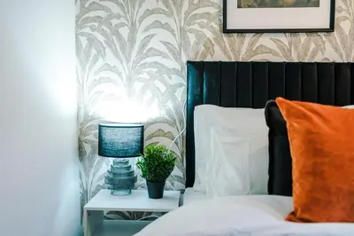 a bedroom with a bed and a table with a lamp at Modern 3BR House in Liverpool - Garden in Liverpool
