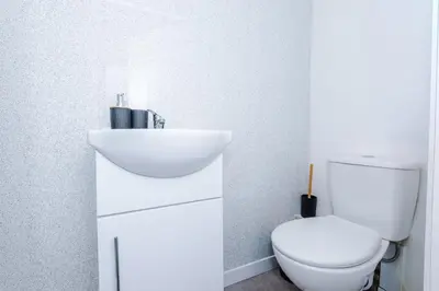 a white bathroom with a toilet and a sink at Modern 3BR House in Liverpool - Garden in Liverpool