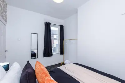 a bedroom with a bed and two mirrors at Modern 3BR House in Liverpool - Garden in Liverpool