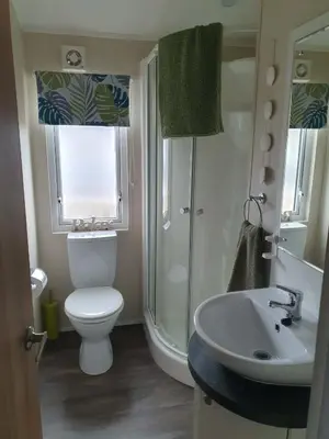 a bathroom with a toilet and a sink and a shower at Jasper Lodge in Morecambe