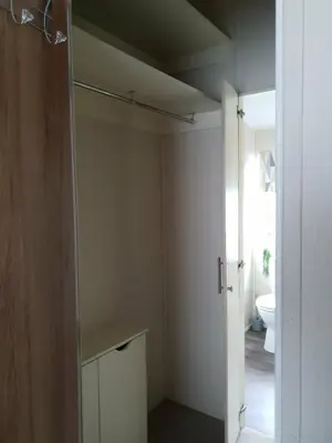 a bathroom with a closet with a toilet in it at Jasper Lodge in Morecambe