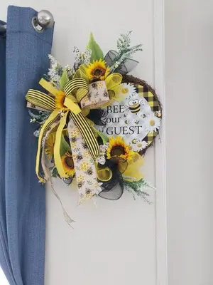 a sunflower door wreath with a sign that reads keep your guest at Jasper Lodge in Morecambe