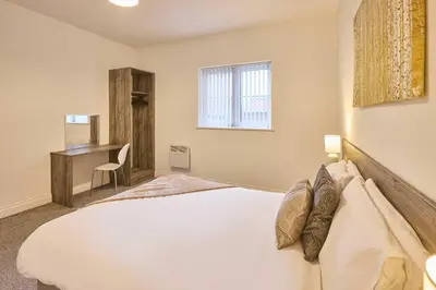 a bedroom with a white bed and a desk at Host & Stay - Showtime Studio in Blackpool