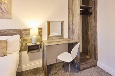 a bedroom with a desk with a chair and a mirror at Host & Stay - Illumination Suite in Blackpool