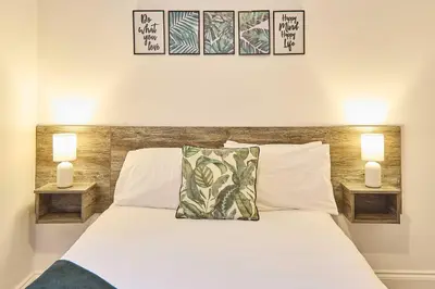 a bedroom with a white bed with two lamps at Host & Stay - Illumination Suite in Blackpool