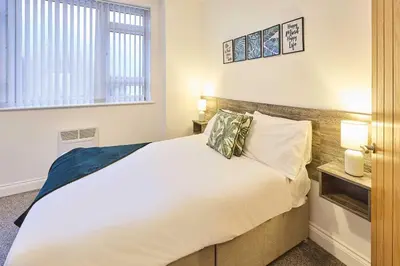 a bedroom with a large white bed and a window at Host & Stay - Illumination Suite in Blackpool