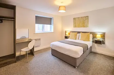 a bedroom with a bed and a desk and a window at Host & Stay - Sandcastle Apartment in Blackpool