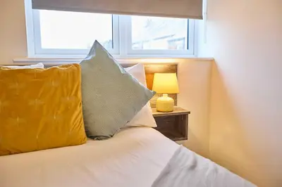 a bed with two pillows and a lamp next to a window at Host & Stay - Sandcastle Apartment in Blackpool