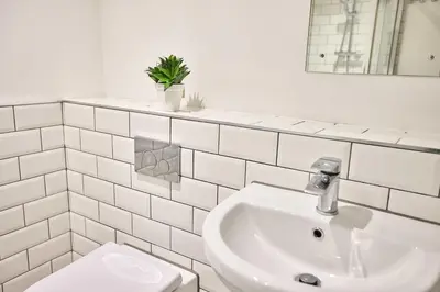 a white bathroom with a sink and a toilet at Host & Stay - Sandcastle Apartment in Blackpool