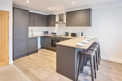 a kitchen with gray cabinets and a counter top at Host & Stay - Sandcastle Apartment in Blackpool