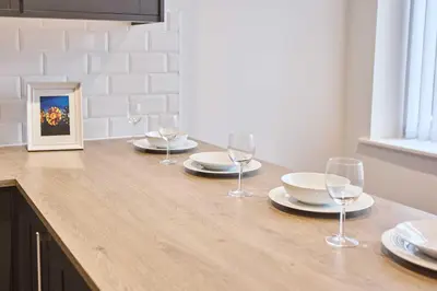 a table with plates and wine glasses on it at Host & Stay - Sandcastle Apartment in Blackpool