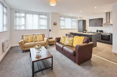 a living room with two couches and a kitchen at Host & Stay - Promenade Suite in Blackpool