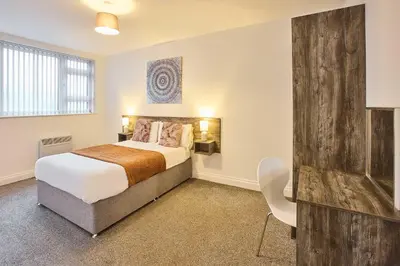 a bedroom with a bed and a chair in it at Host & Stay - Promenade Suite in Blackpool