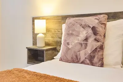 a bed with a pillow and a lamp on a table at Host & Stay - Promenade Suite in Blackpool