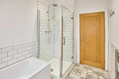 a bathroom with a tub and a shower with a glass door at Host & Stay - Promenade Suite in Blackpool