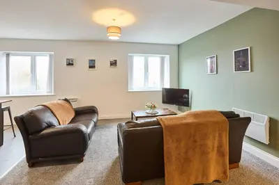 a living room with two leather chairs and a tv at Host & Stay - Tower Suite in Blackpool
