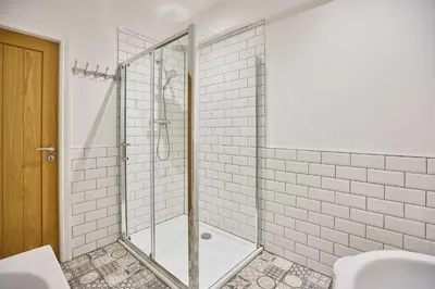 a bathroom with a shower with white tiles at Host & Stay - Tower Suite in Blackpool