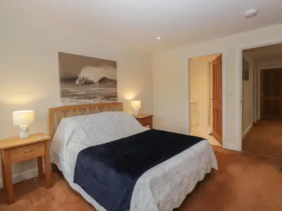 a bedroom with a large bed and two night stands at 6 Swan House in Carnforth