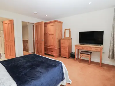 a bedroom with a bed and a desk with a television at 6 Swan House in Carnforth