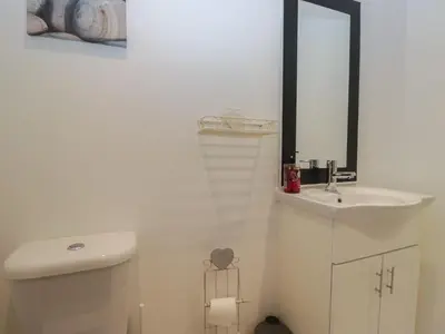a white bathroom with a sink and a mirror at 6 Swan House in Carnforth