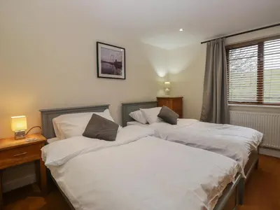 two twin beds in a room with a window at 6 Swan House in Carnforth