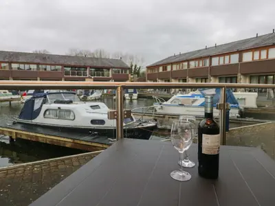 a bottle of wine sitting on a table with a wine glass at 6 Swan House in Carnforth