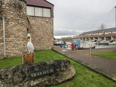 a statue of a seagull sitting on a rock next to a house at 6 Swan House in Carnforth